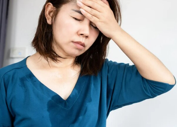 다한증 땀이 많이 흐르는 증상으로 옷이 젖어 힘들어하는 여자환자의 모습